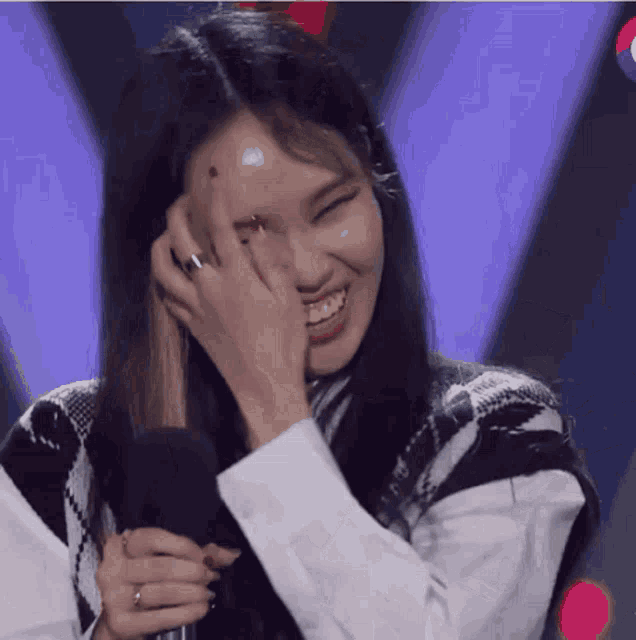 a woman with a ring on her finger is smiling and covering her face with her hand