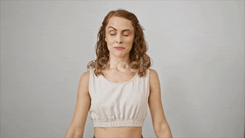 a woman in a white tank top is flexing her biceps