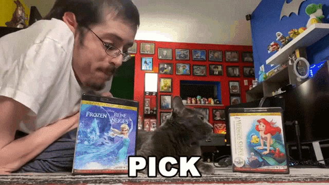 a man is petting a cat while looking at a frozen movie and a mermaid movie
