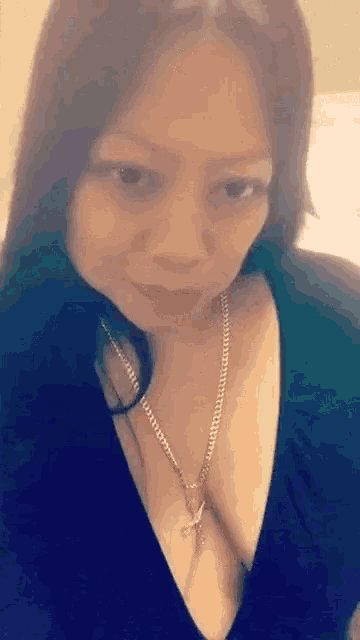 a woman wearing a black top and a necklace with a cross