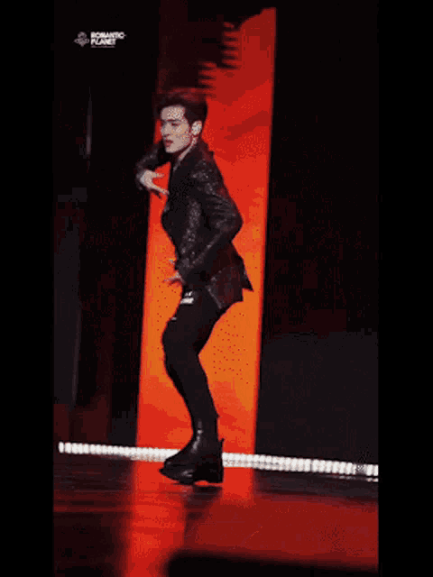 a man is dancing on a stage with the words romantic planet written above him