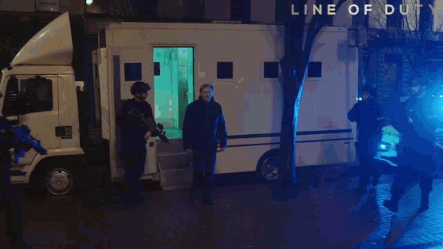 a group of police officers walking in front of a line of duty sign