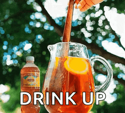 a pitcher of iced tea is being poured into a pitcher with a spoon .