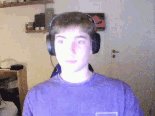 a young man is wearing headphones and a purple shirt .