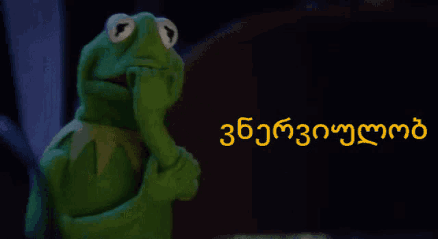 kermit the frog covering his mouth with his hand in front of a sign that says ' georgian ' on it