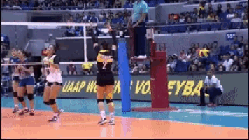 a volleyball game is being played in front of a banner that says uaap volleyball