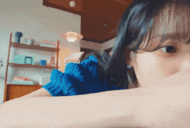 a close up of a woman 's face with a blue top on