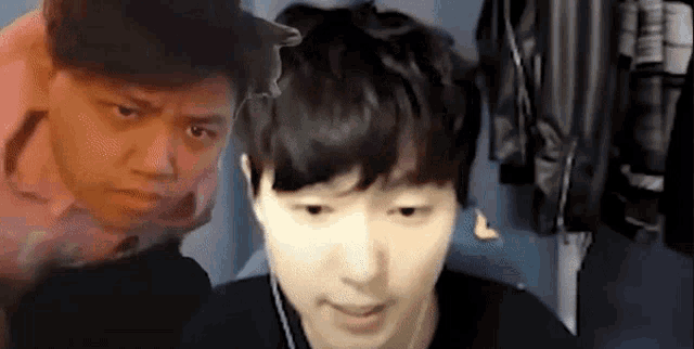a man is making a funny face in front of another man 's face .