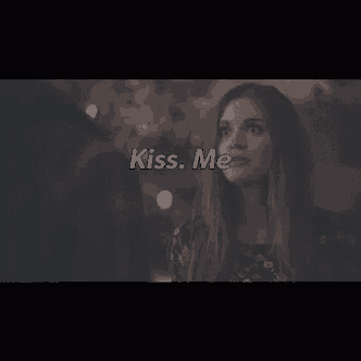 a man and a woman are kissing with the words `` kiss me '' written on the bottom of the image .