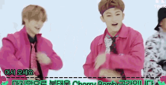 a man in a pink jacket and tie is dancing with another man .