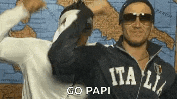 two men wearing sunglasses and a jacket with the word italia on it are standing next to each other .