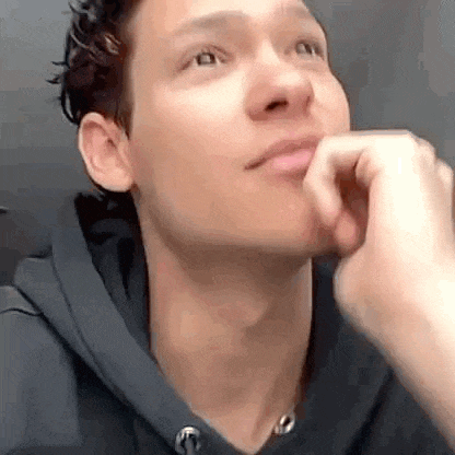 a close up of a man 's face with his hand to his chin .