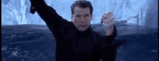 a man in a black turtleneck is standing in the water holding a sword .