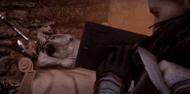 a man with horns is laying on a bed while a woman looks on