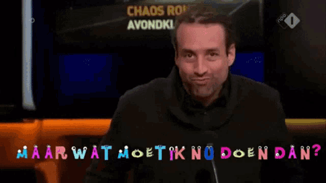 a man is sitting in front of a screen that says chaos rond avondklok