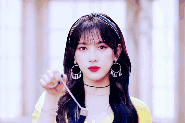 a woman wearing a choker and earrings is holding a key in her hand