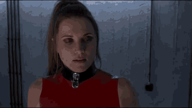 a woman wearing a red top and a black collar