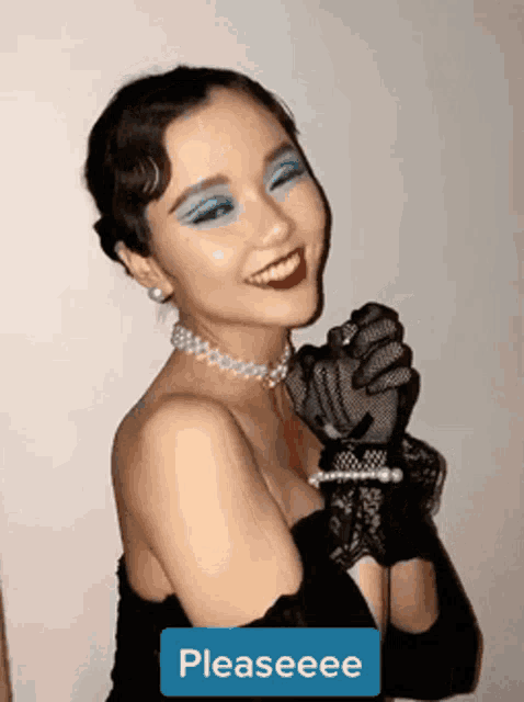 a woman wearing gloves and a necklace with a pleaseee sticker