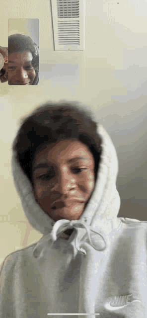 a person wearing a grey nike hoodie with a hood