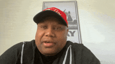 a man wearing a red hat with the letter y on it looks at the camera