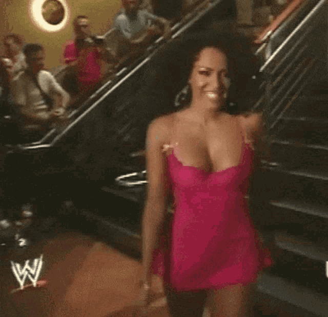 a woman in a pink dress with a w logo on the bottom right