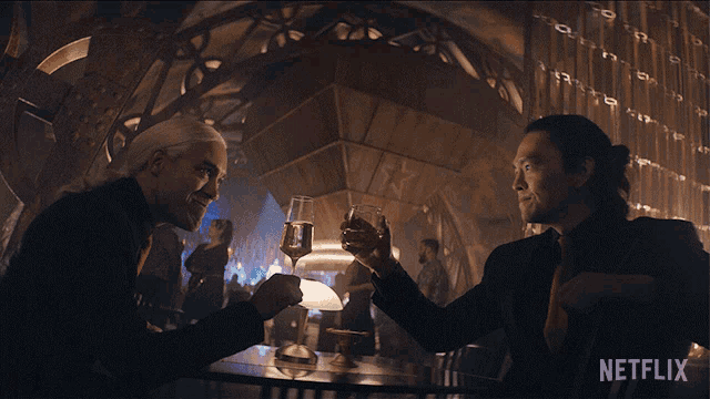 two men sitting at a table with a netflix logo on the bottom