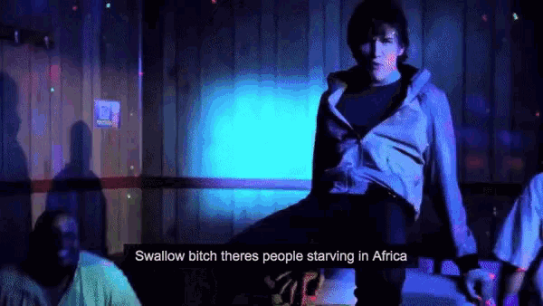 a man is standing in front of a sign that says " swallow bitch there 's people starving in africa "