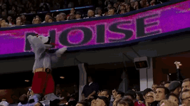 a mascot stands in front of a purple sign that says noise