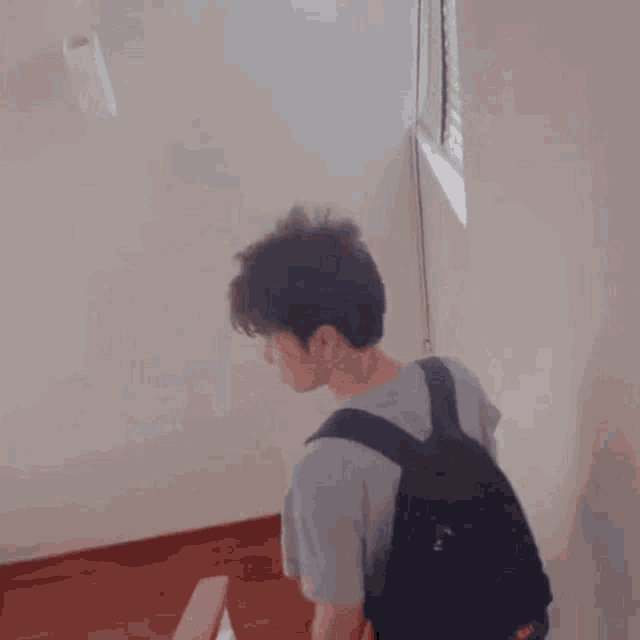a young man with a backpack is making a funny face and smiling .
