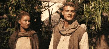 a man and a woman are standing next to each other in a forest