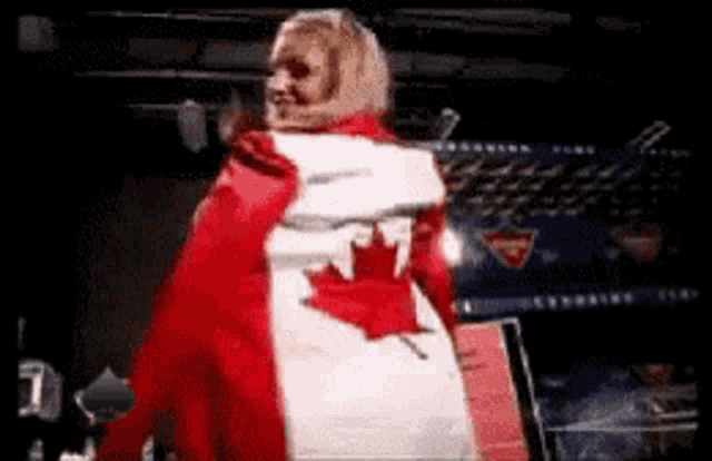 a woman in a red jacket with a canadian flag draped over her back