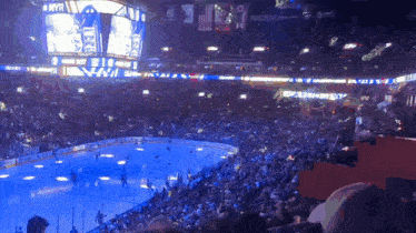a hockey game is being played in a stadium with the number 61 on the score board