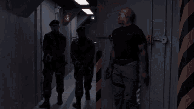 three soldiers walking down a hallway with a play button on the bottom