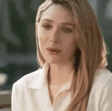 a close up of a woman 's face with a white shirt on .