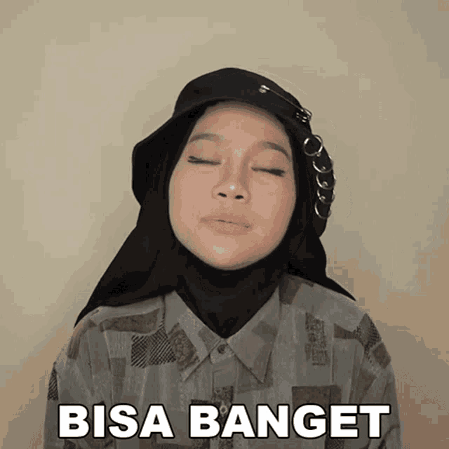 a woman wearing a hijab and a hat with the word bisa banget on the bottom right