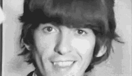 a close up of a man 's face with a hat on and smiling in a black and white photo .