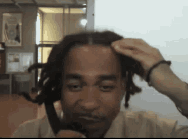 a man with dreadlocks is talking on a cellphone