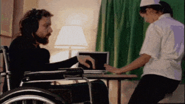 a man in a wheelchair is being helped by a woman in a white shirt