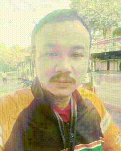 a man with a mustache is standing in front of a building .