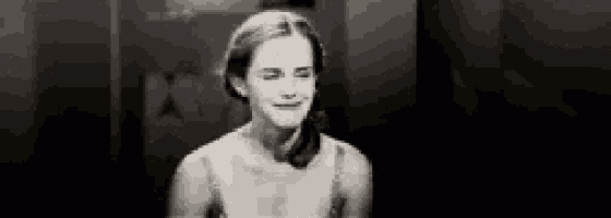 a black and white photo of a woman without a shirt smiling .
