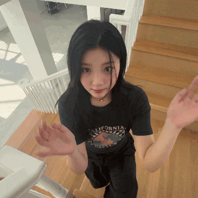 a woman wearing a black california shirt is standing on a set of stairs