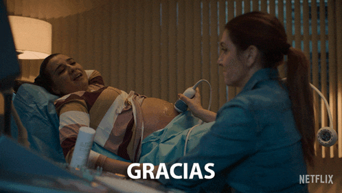a pregnant woman is being examined by a doctor and the word gracias is on the bottom right