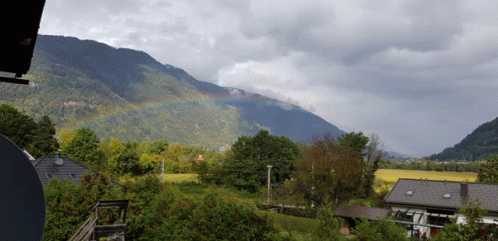 a view of a mountain with a rainbow in the distance