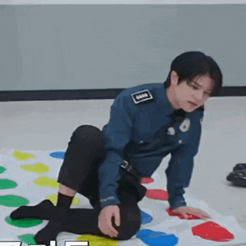 a police officer is playing a twister game on the floor .