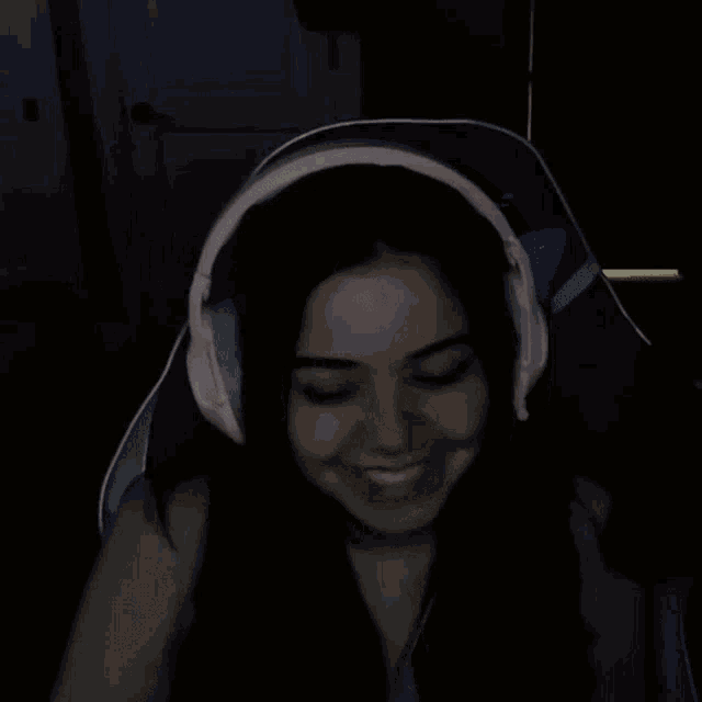 a girl wearing pink headphones is making a middle finger sign
