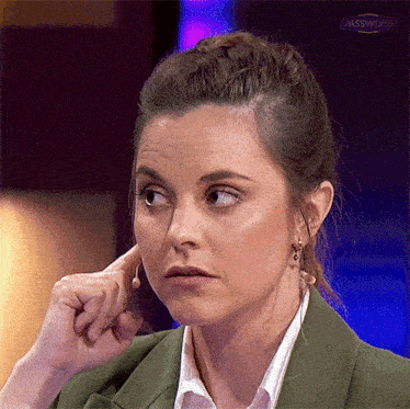 a woman covering her ear with her hand in front of a sign that says passworf