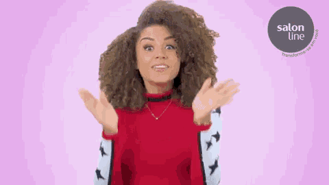 a woman with curly hair is making a surprised face and clapping her hands .