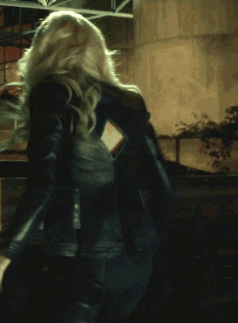 a woman in a black jacket with the words kill him below her