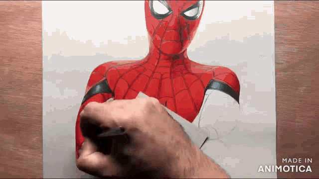a person is drawing a spider-man on a piece of paper .