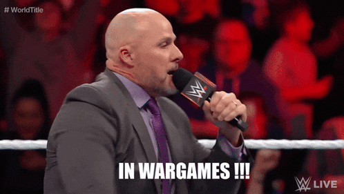 a man in a suit and tie is talking into a microphone and says in wargames !!!